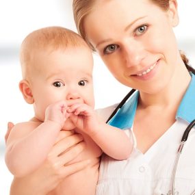Pediatrician woman doctor holding in his arms baby